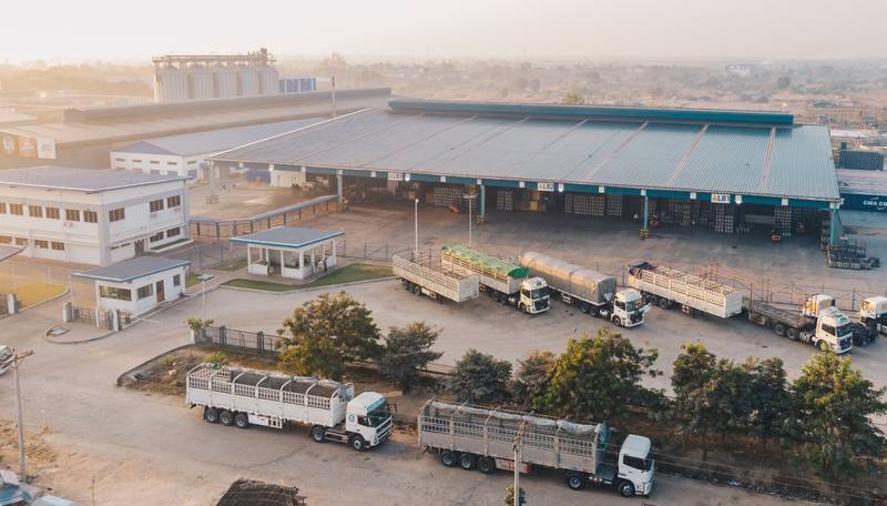 aerial-view-factory-trucks-parked-near-warehouse-daytime