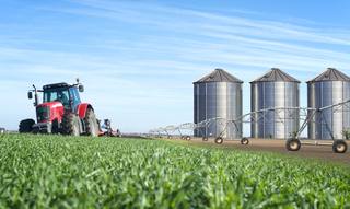 agriculture-food-production-concept-with-tractor-machine-silos-irrigation-system
