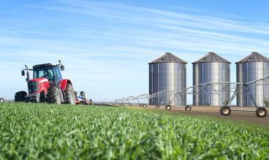 agriculture-food-production-concept-with-tractor-machine-silos-irrigation-system