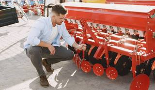 agronomist-choosing-new-planter-man-outdoor-ground-shop-agricultural-machinery