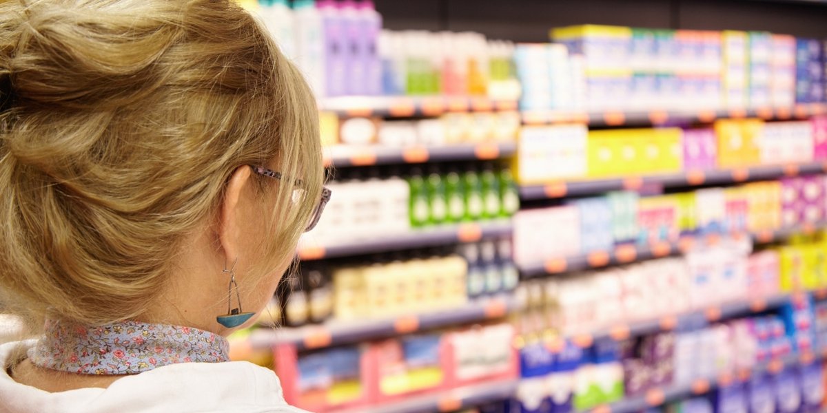back-shot-grandmother-with-blonde-hair-shopping-local-supermarket-pushing-cart-forward-going-household-chemistry