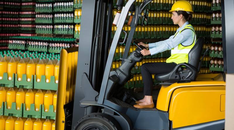 confident-female-worker-driving-forklift-warehouse