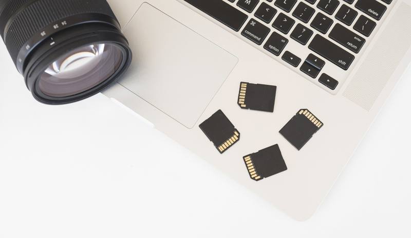elevated-view-dslr-camera-memory-cards-laptop-keyboard