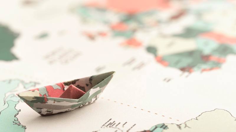 high-angle-small-origami-boat-world-map