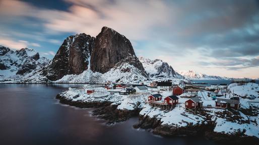 horizontal-shot-shore-town-with-red-houses-near-sea-snowy-mountain-back