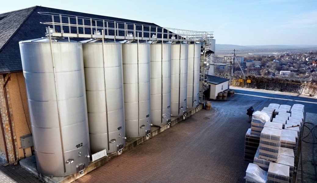 metal-wine-storage-tanks-with-dwelling-houses-background-winery
