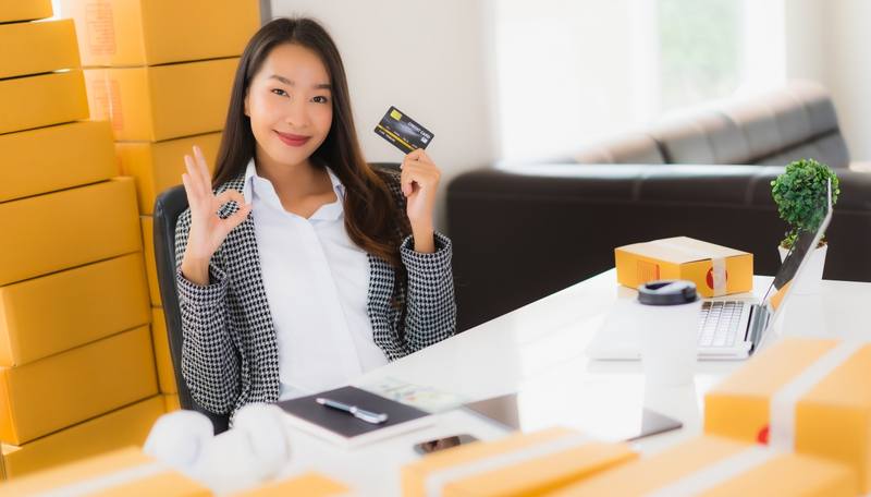 portrait-beautiful-young-asian-woman-work-from-home-with-credit-card-cardboard-box-ready-shipping-shopping