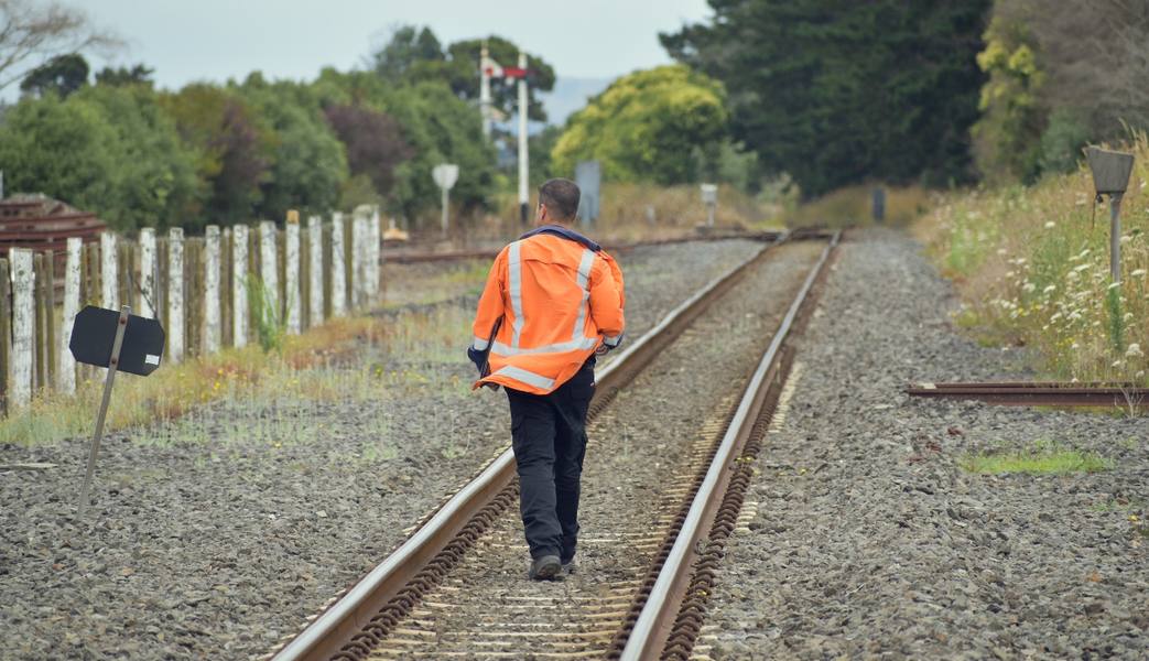 railroad-worker-walking-away-rail-tracks