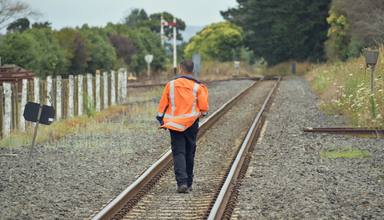railroad-worker-walking-away-rail-tracks