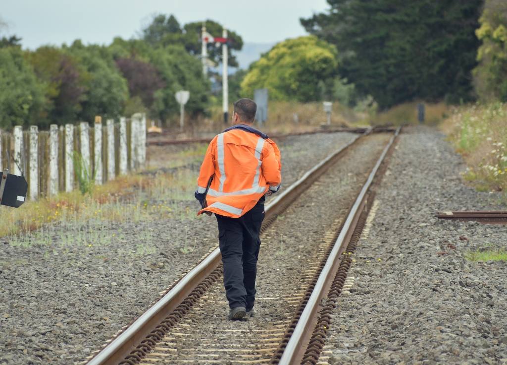 railroad-worker-walking-away-rail-tracks