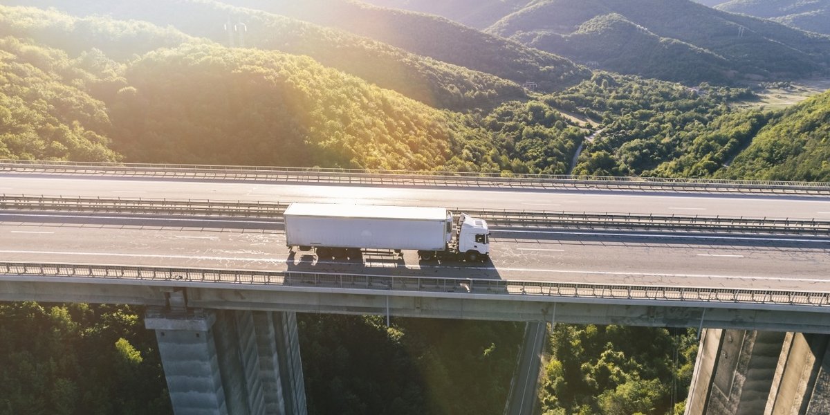 wp-3e7f7a13a50fc09e-trucks-highway-mountain-sunset