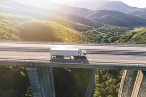 wp-3e7f7a13a50fc09e-trucks-highway-mountain-sunset