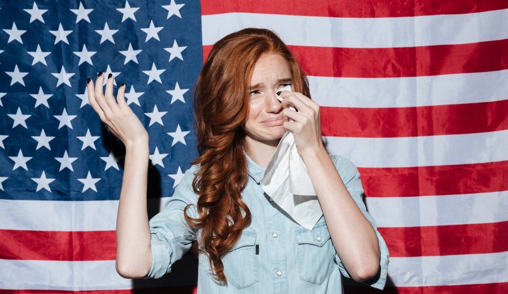 wp-5f199b0d0538ce3b-sad-redhead-young-lady-cry-usa-flag-looking-aside