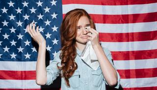 wp-5f199b0d0538ce3b-sad-redhead-young-lady-cry-usa-flag-looking-aside