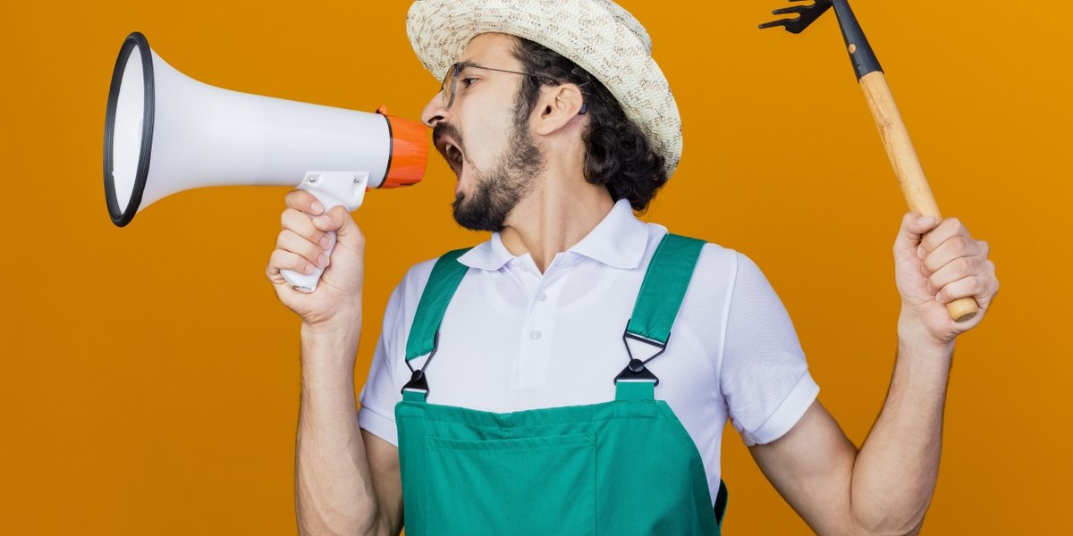 wp-6f892ede8f0c77a4-young-bearded-gardener-man-wearing-jumpsuit-hat-holding-mini-rake-shouting-megap