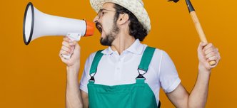 wp-6f892ede8f0c77a4-young-bearded-gardener-man-wearing-jumpsuit-hat-holding-mini-rake-shouting-megap