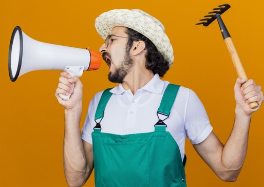 wp-6f892ede8f0c77a4-young-bearded-gardener-man-wearing-jumpsuit-hat-holding-mini-rake-shouting-megap