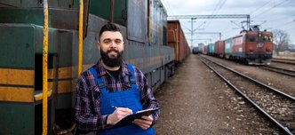 wp-7f72834bcc95f5dd-portrait-engine-train-driver-standing-by-locomotive-train-station-holding-depart