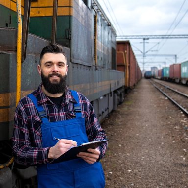 wp-7f72834bcc95f5dd-portrait-engine-train-driver-standing-by-locomotive-train-station-holding-depart