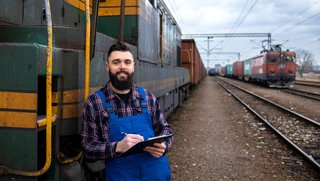 wp-7f72834bcc95f5dd-portrait-engine-train-driver-standing-by-locomotive-train-station-holding-depart