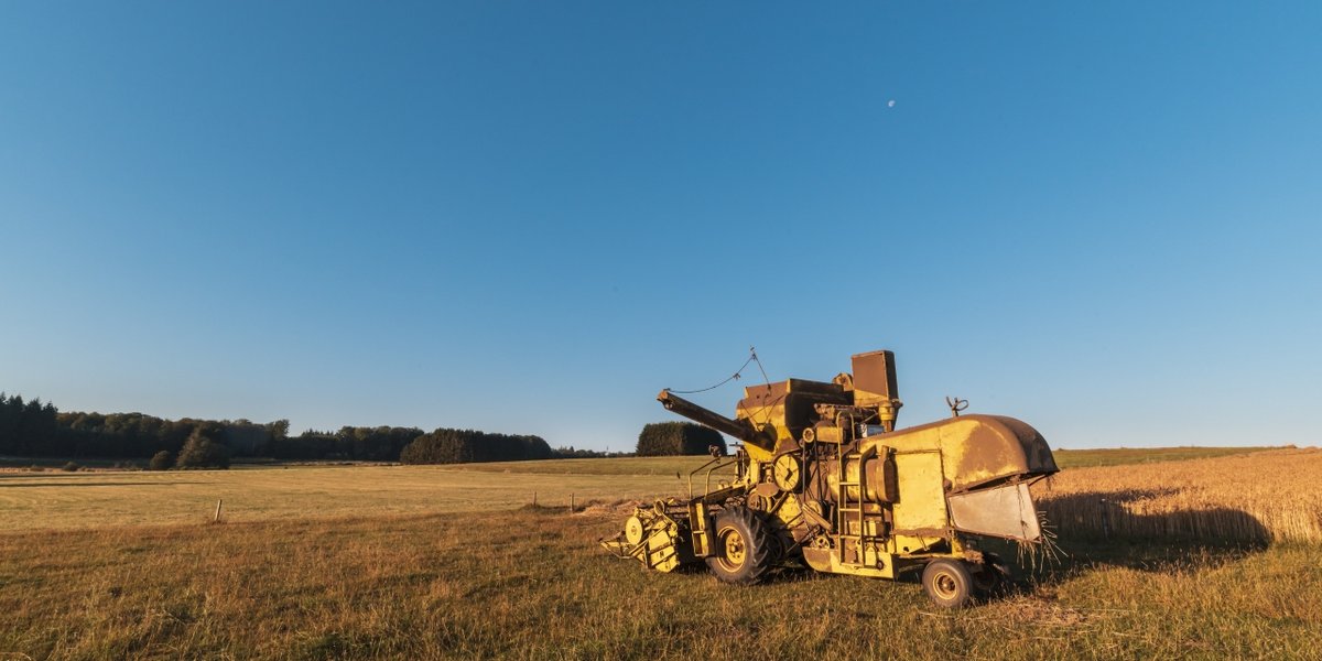 wp-83a4f00ab0cd0c80-beautiful-shot-harvester-machinery-farm-with-blue-sky-background