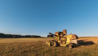 wp-83a4f00ab0cd0c80-beautiful-shot-harvester-machinery-farm-with-blue-sky-background