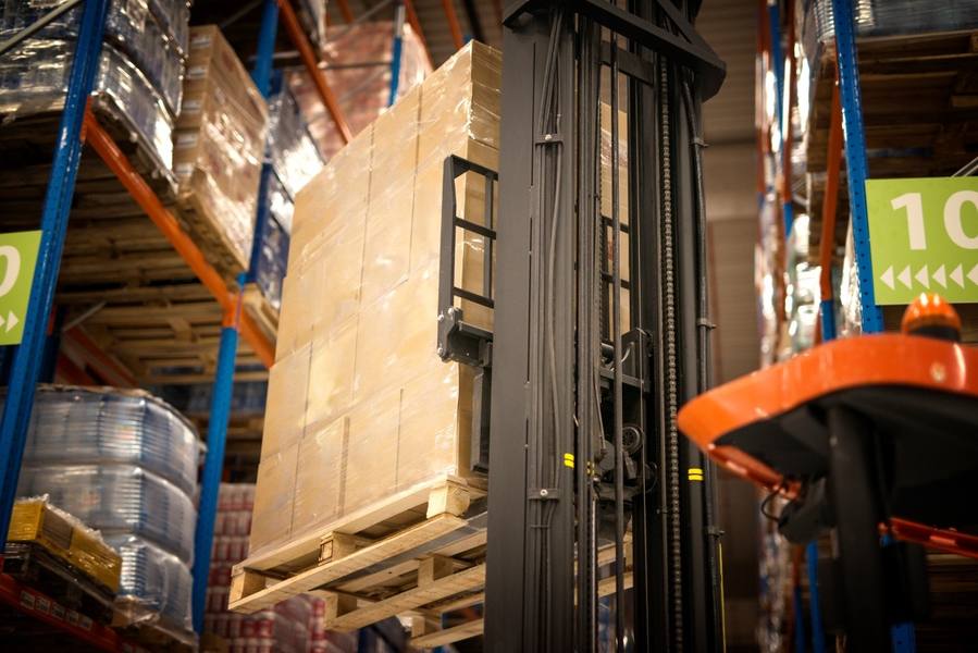 wp-9de0ab316aec7bb8-industrial-forklift-machine-lifting-palette-full-cardboard-boxes-placing-them-sh