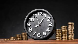 wp-a9bec136c8ae555d-round-clock-increasing-coins-wooden-desk-against-black-backdrop