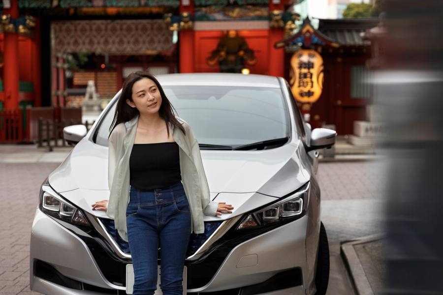 wp-c8af6b8aace456a0-woman-posing-her-new-electric-car