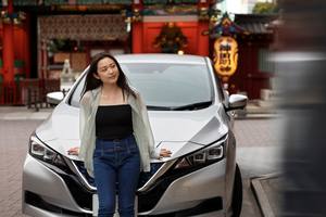 wp-c8af6b8aace456a0-woman-posing-her-new-electric-car