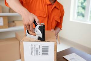 wp-d073671527feea8c-close-up-courier-preparing-package-delivery
