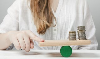 wp-d44ed5274ccd6131-woman-holding-her-finger-balance-with-coins