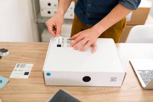 wp-e0d10b00a16d3ab4-close-up-male-hands-putting-shipping-label-package-arranging-online-customers-or