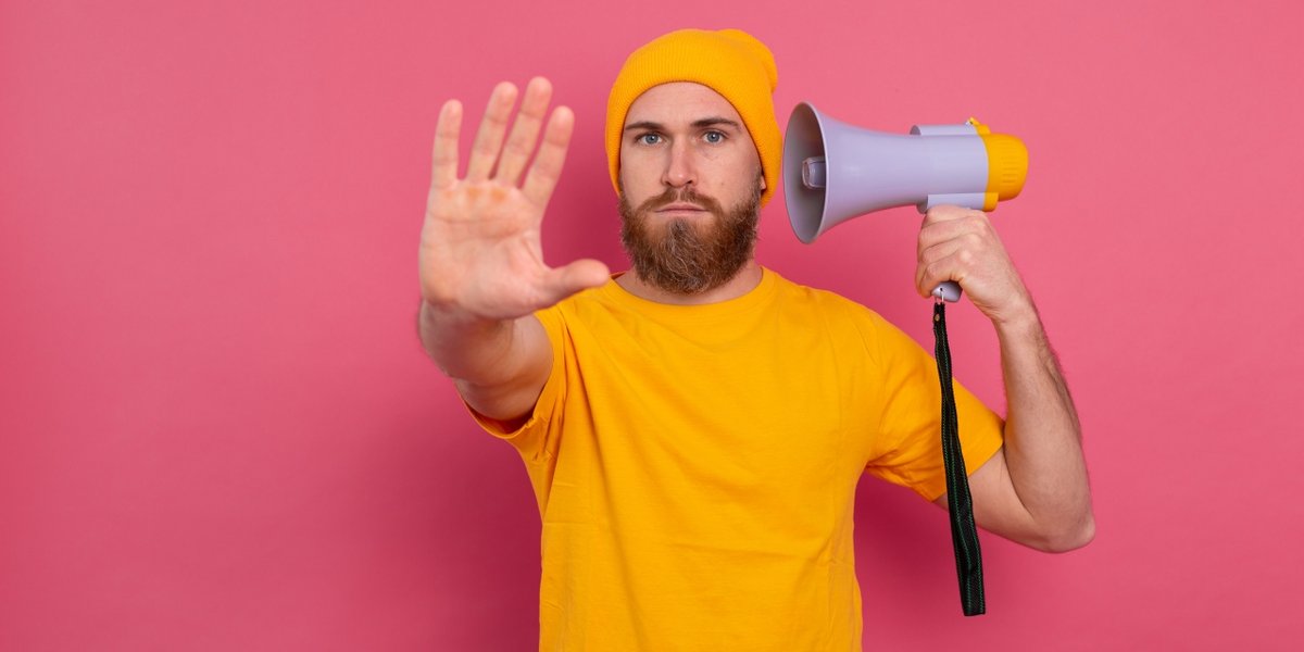 wp-fc9660756ec6fb30-european-man-hold-megaphone-show-stop-sign-pink-background