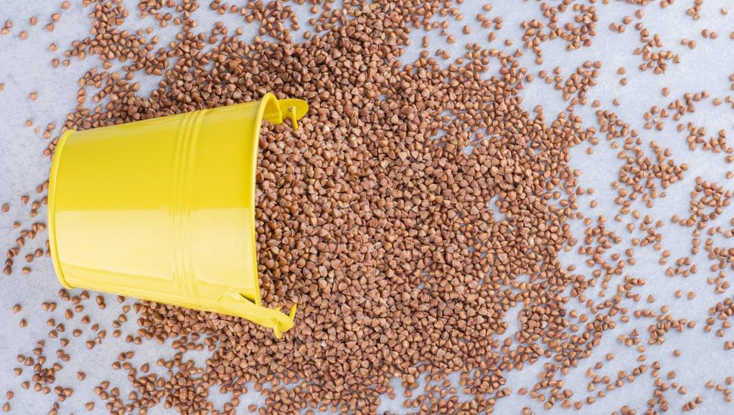 yellow-bucket-lodged-pile-scattered-buckwheat-marble-surface