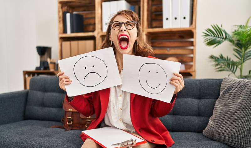 young-beautiful-woman-working-depression-holding-sad-happy-emotion-paper-angry-mad-screaming-frustrated-furious-shouting-with-anger-looking-up